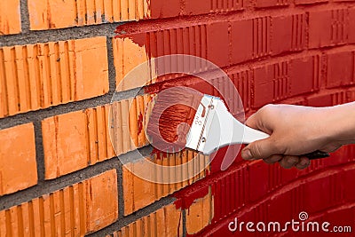 Human hand painting wall with red color