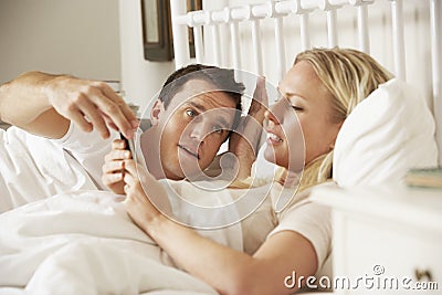 Husband Complaing As Wife Uses Mobile Phone In Bed Stoc