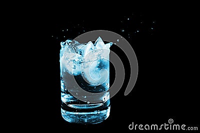 Ice in glass and water splash isolated on black