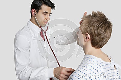 Indian doctor examining male patient with stethoscope