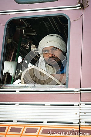 Indian driver in white turban in the cabin of his truck