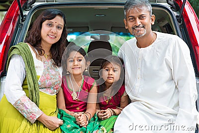 Indian family sitting in car.