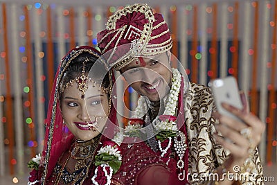 Indian Hindu Bride & Groom a happy smiling couple shooting self with mobile.