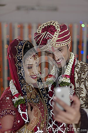 Indian Hindu Bride & Groom a happy smiling couple shooting self with mobile.