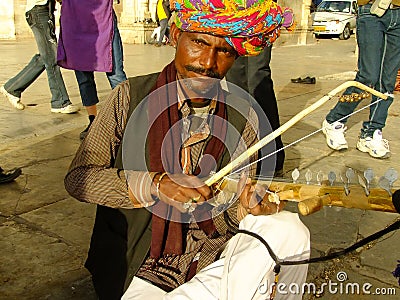 Indian man playing ravanahatha at Lake Pichola, Udaipur, India