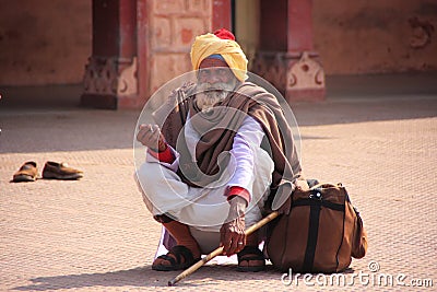 Indian man sitting at train station, Sawai Madhopur, India
