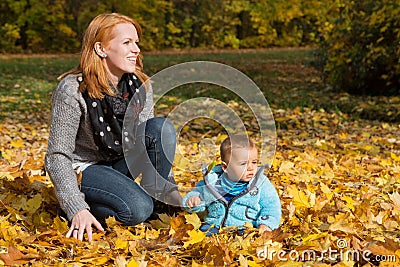 Indian summer: Young woman with her baby in autumn. Family conce