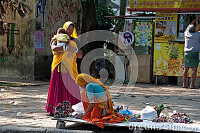 Indian woman in colorful sari sells souvenirs, bangles and cheap jewelry