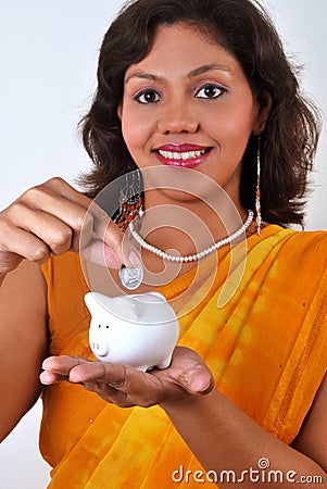 Indian woman saving money in piggy bank