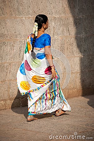 Indian woman in traditional colorful sari and bangles going to Hindu religious ceremony