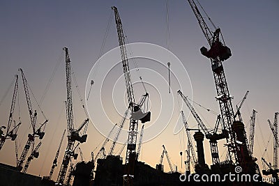 Industrial crane at construction site during sunset.