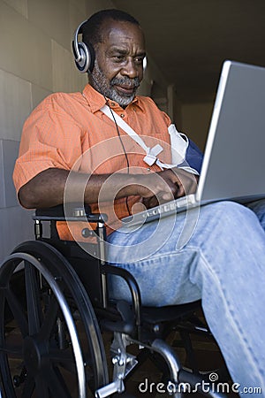 Injured Man Using Laptop And Listening To Music