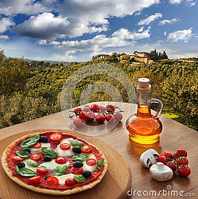 Italian pizza in Chianti against olive trees and villa in Tuscany, Italy