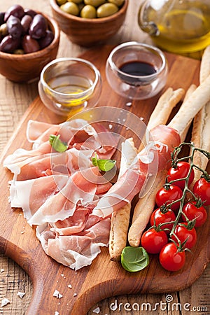 Italian prosciutto ham grissini bread sticks tomato olive oil