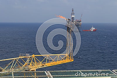 Jack up drilling rig, flare boom, and crew boat in the middle of