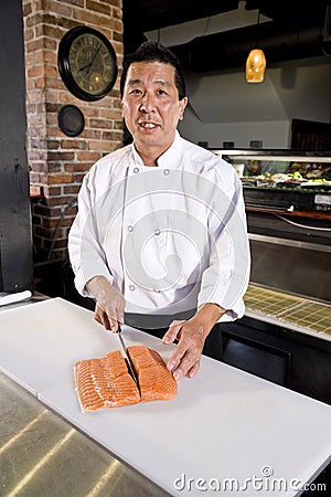 Japanese chef slicing raw fish for sushi