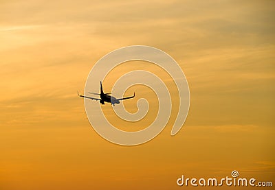 Jetliner flying against red sunset sky
