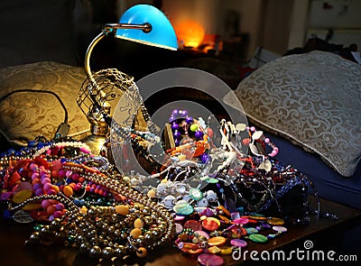 Jewels and necklaces on the jewelry pile below the lamp