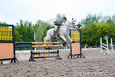 Jockey jumps over a hurdle