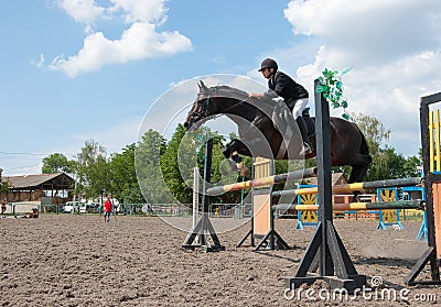 Jockey jumps over a hurdle