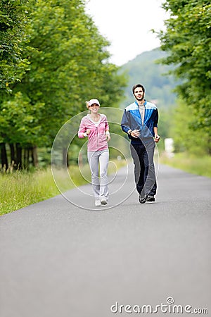 Jogging sportive young couple running park road