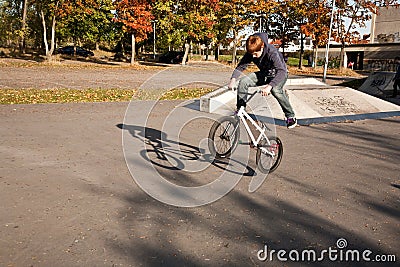 Joung red haired boy jumps with his BMX Bike at the skate park