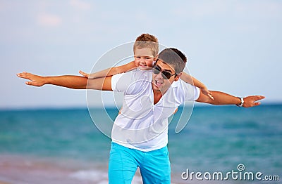 Joyful father and son having fun on the beach