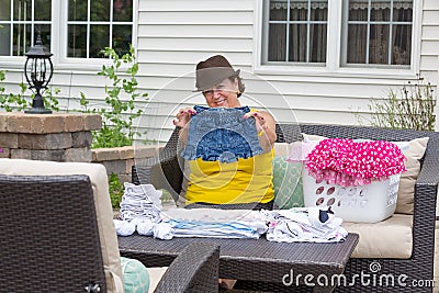 Joyful Granny folding her granddaughters clothes