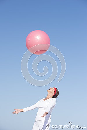 Joyful senior woman and flying exercise ball