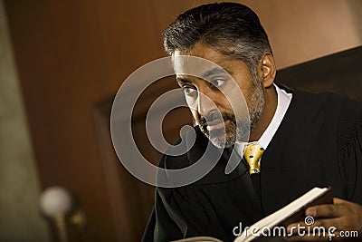 Judge With Book Looking Away In Court Room