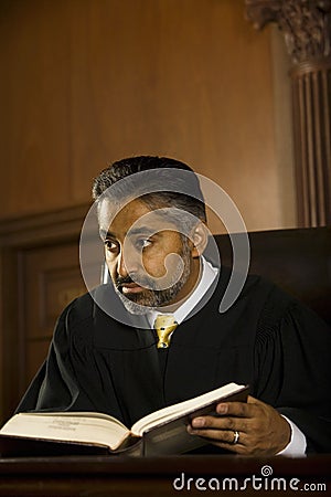 Judge With Book Looking Away In Court Room