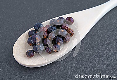 Juniper berries in a wood spoon