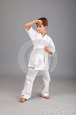 Karate boy in white kimono fighting