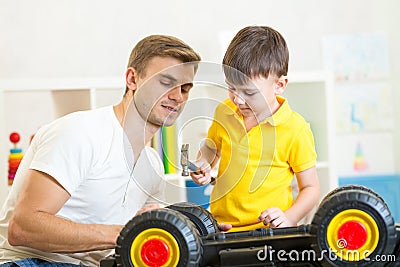 Kid boy and his dad repair toy car