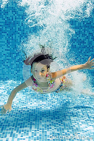 Kid jumps to swimming pool, underwater view