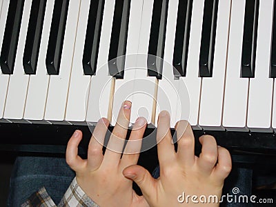 Kid playing piano, close up of keyboard and hands