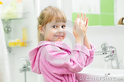 Kid washing her hands in bathroom