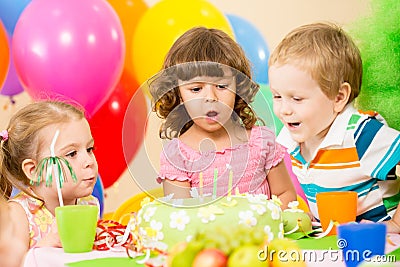 Kids celebrate birthday party blowing candles