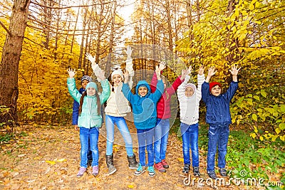 Kids group with arms up standing in row together