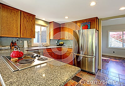 Kitchen with stove and red tea pot.