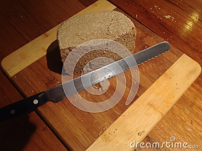 Knife and Homemade Bread on Rustic Wooden Board.