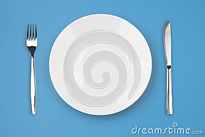 Knife, plate, fork on colorful background top view