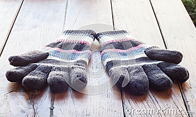 Knit winter gloves on wood table