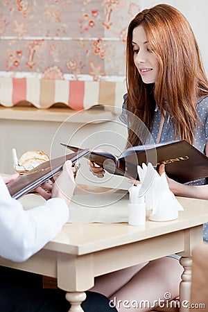 Lady keeps the menu to make an order