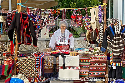 Lady in traditional clothes selling on booth Editorial Stock Image