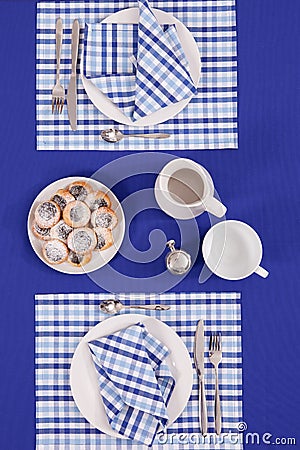 Laid table - fork and spoon laid on blue cloth and white plate