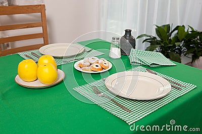 Laid table - fork and spoon laid on green cloth and white plate