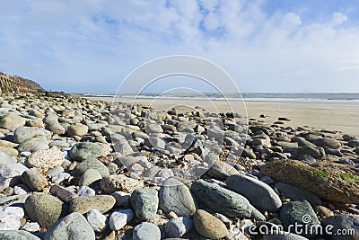 Landscape format wide angle pebble beach and blue sky