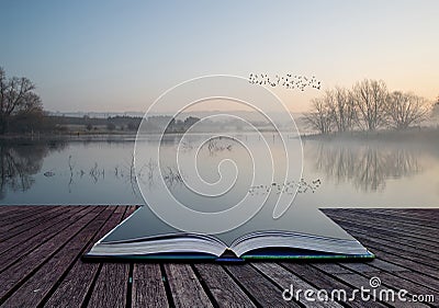 Landscape of lake in mist with sun glow at sunrise