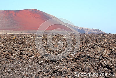 Empty landscape of lava fields and red volcano
